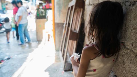 A young girl looks on a bustling street in Manila's Tondo neighborhood.
