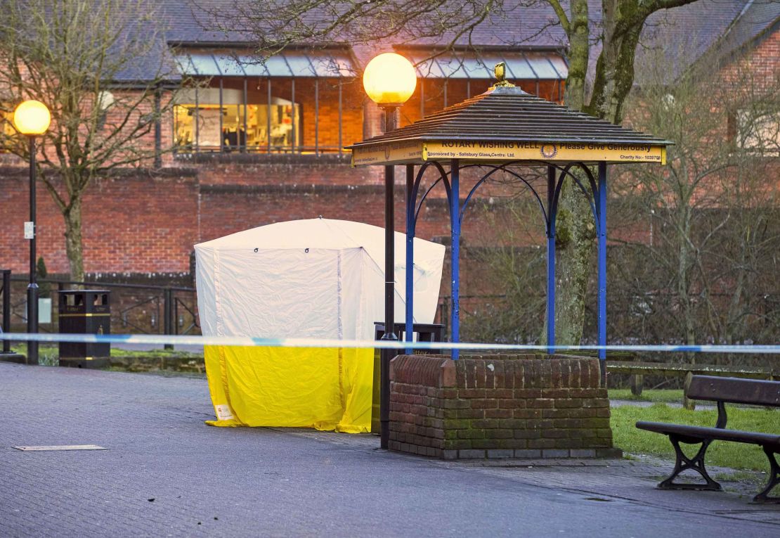 Investigators leave the park bench in Salibury covered with a forensic tent Tuesday.