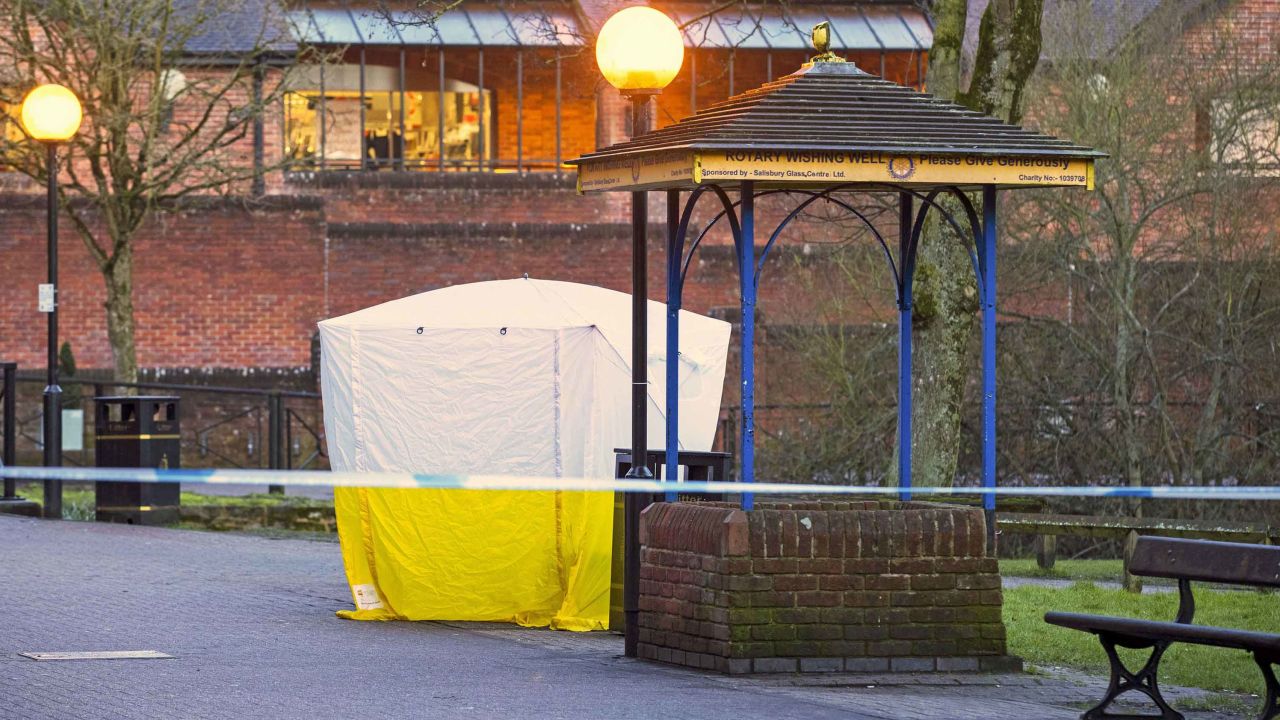 Investigators leave the park bench in Salibury covered with a forensic tent Tuesday.