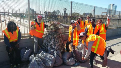 Homeless workers pose with  trash they cleaned up from the streets of San Diego.