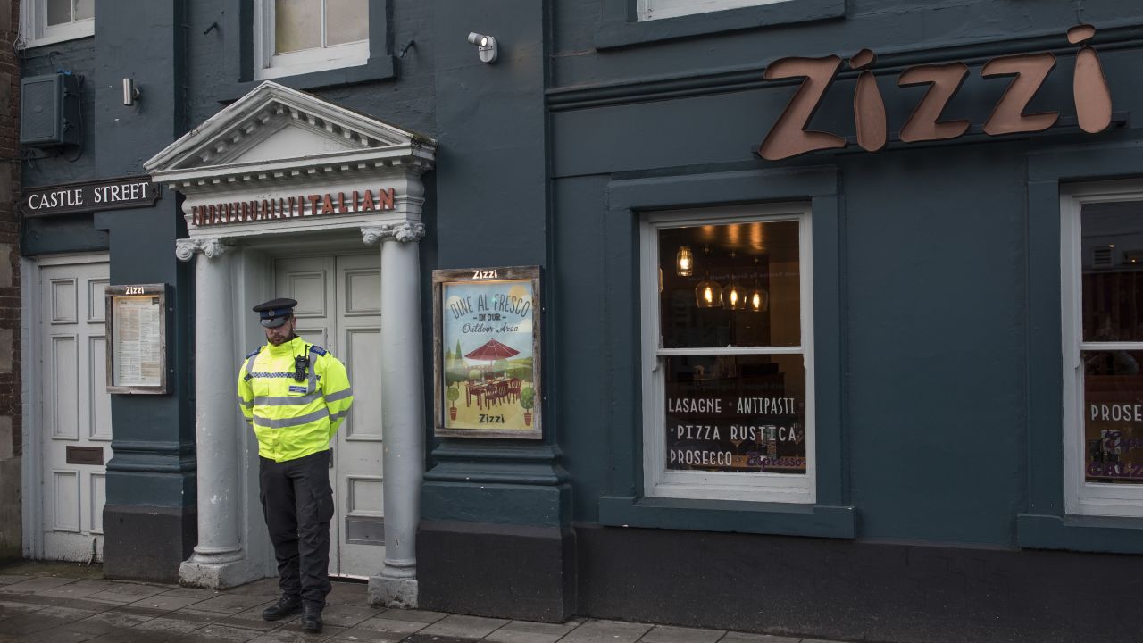 An officer stands outside the nearby Zizzi restaurant, which was closed Tuesday.