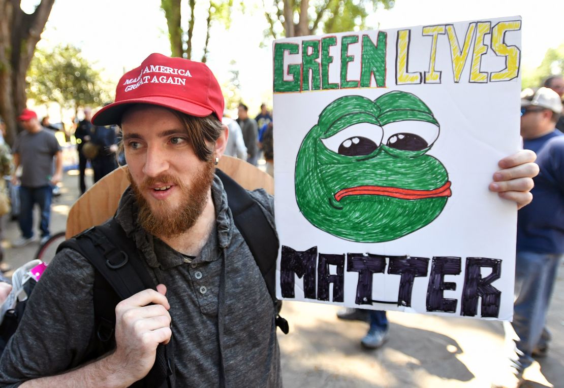 Andrew Knight holds a sign of Pepe the frog, a conservative icon, during a rally in Berkeley, California on April 27, 2017. 
