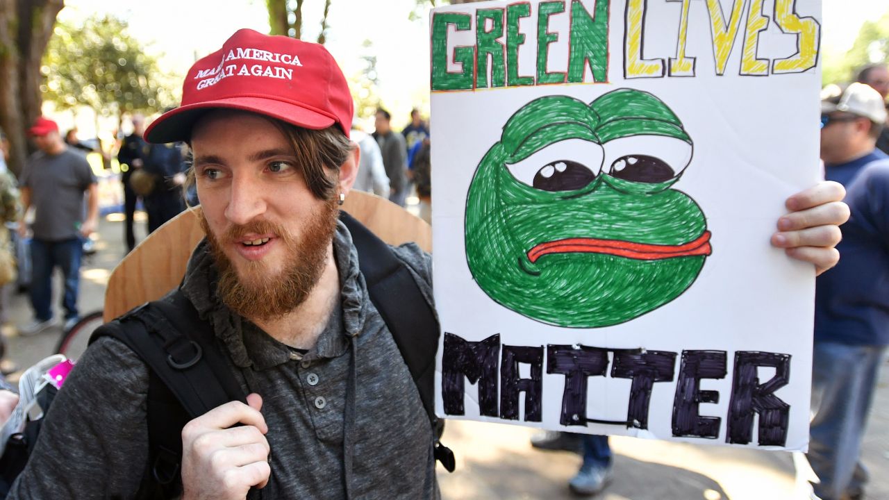 Andrew Knight holds a sign of Pepe the frog, a conservative icon, during a rally in Berkeley, California on April 27, 2017. 
