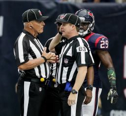 Shawn Hochuli (No. 83) and field judge Tom Hill discuss a flag thrown on a play in 2016.