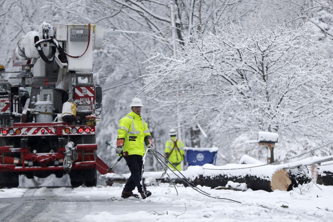 A worker pulls downed lines as a crew tries to restore power Wednesday in Morristown, New Jersey.