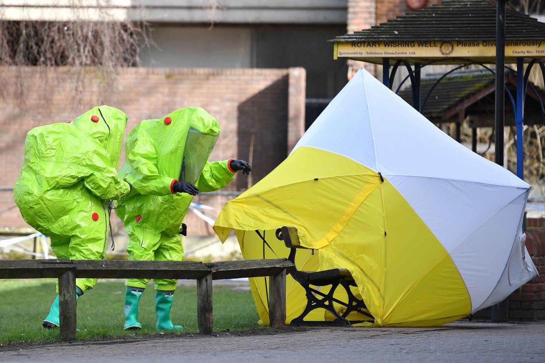 Members of the emergency services in green biohazard suits place a tent over the city center bench where the Skripals were found collapsed on March 4.