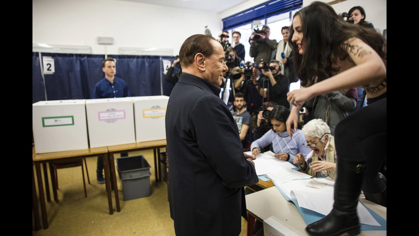 A topless activist from the feminist group Femen interrupts Silvio Berlusconi as the former Italian prime minister votes in Milan on Sunday, March 4. Written on her body in Italian was "Berlusconi, you have expired!" 