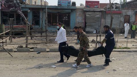 Afghan investigators carry away the body of the alleged assailant on Friday.