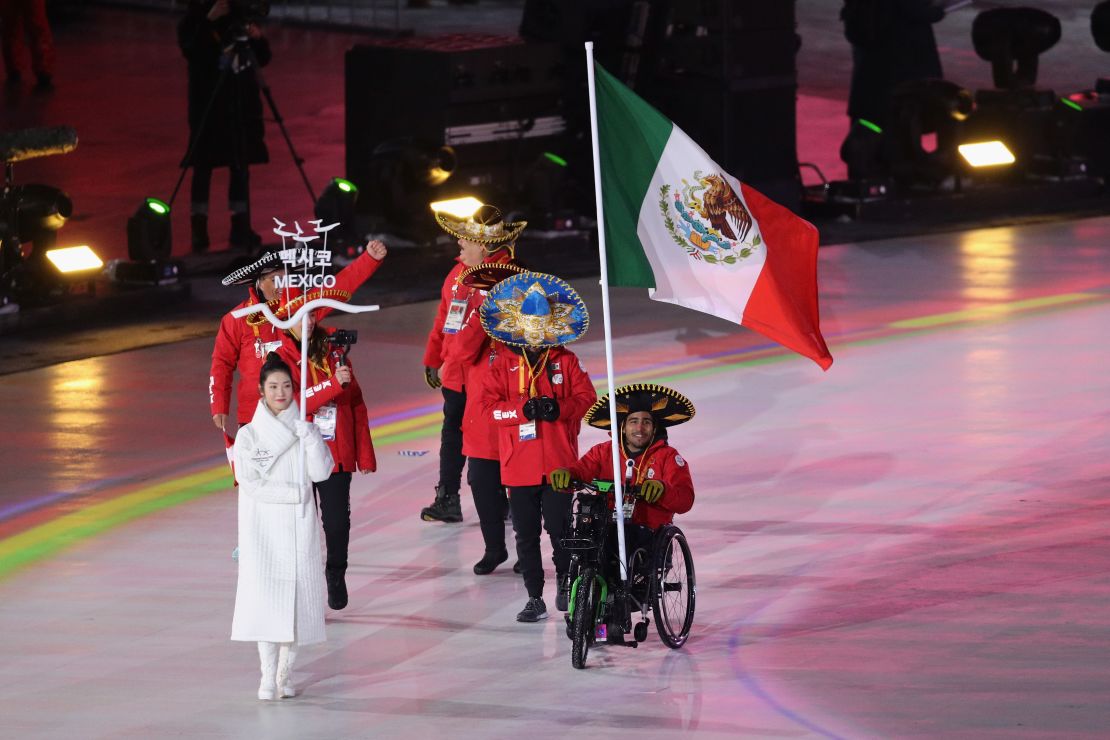 Mexico's sole competitor Arly Aristides Velasquez Penaloza carries his national flag into the arena