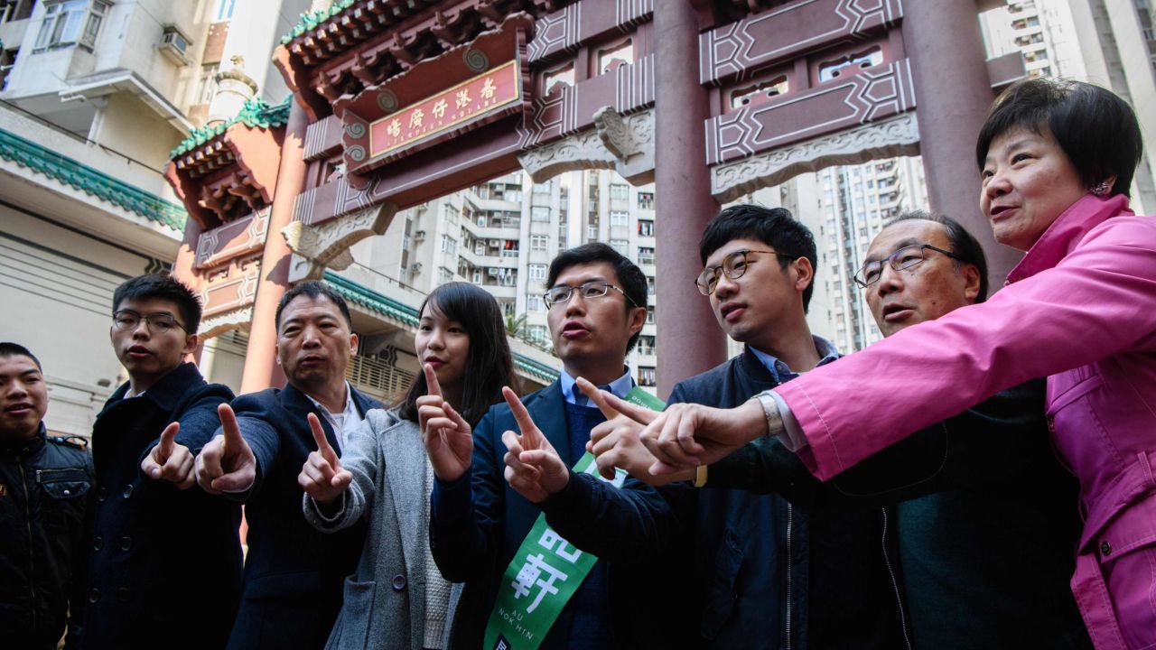 Pro-democracy campaigners Joshua Wong, left, Agnes Chow, third from left, and Nathan Law campaign for by-election candidate Au Nok-hin, center, for the Legislative Council by-elections in Hong Kong on March 11, 2018. 