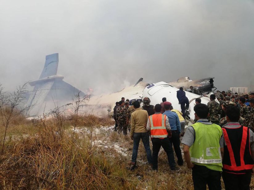 Rescuers survey the plane's smoking debris.