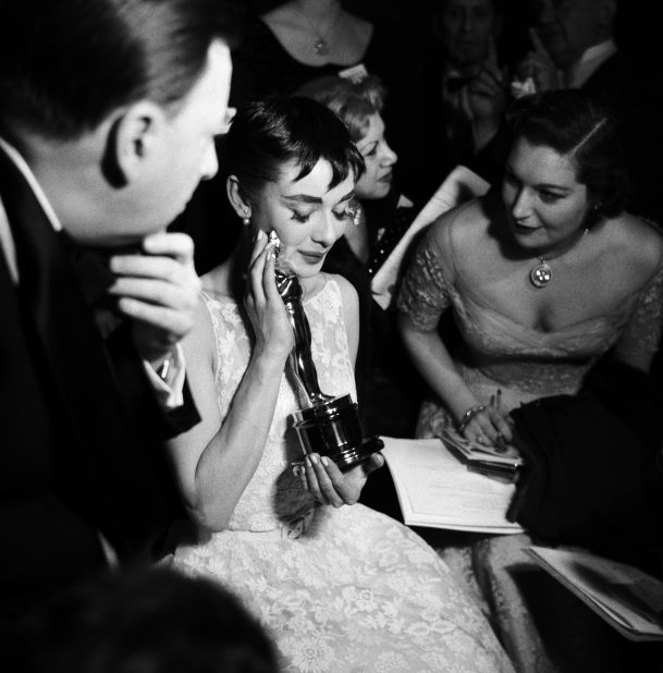Hepburn holds the best actress Oscar she won for "Roman Holiday."