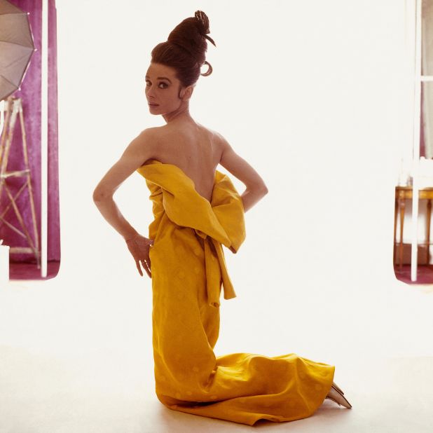 Hepburn wears a strapless yellow silk evening dress with a decolletage like a blooming flower.