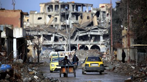 Syrians move along a destroyed street in Raqqa on February 18.