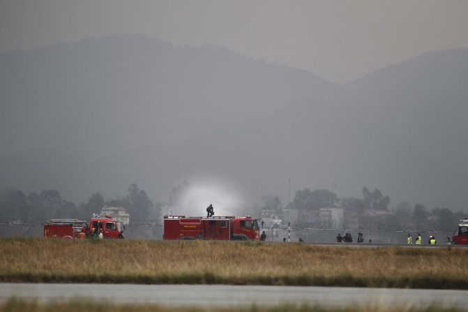 Fire trucks work to extinguish the plane's smoldering wreckage.
