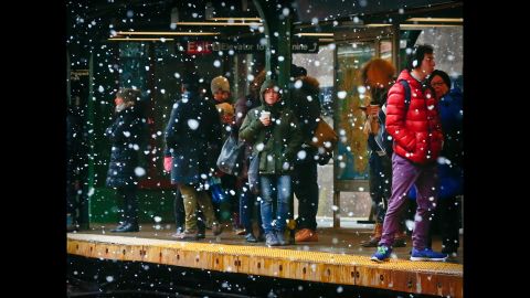 Commuters are sheltered from snowfall while they wait on a subway platform in New York City on March 13.