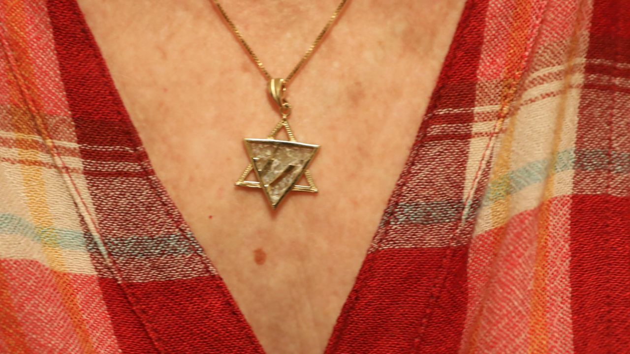 The woman wears a Star of David pendant. To her, the Holocaust is a permanent reminder that people could be kicked out of a country they thought was home.