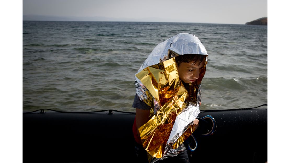 A young Syrian boy is wrapped with a thermal blanket as he arrives with others at the coast on a dinghy after crossing from Turkey, at the island of Lesbos, Greece.