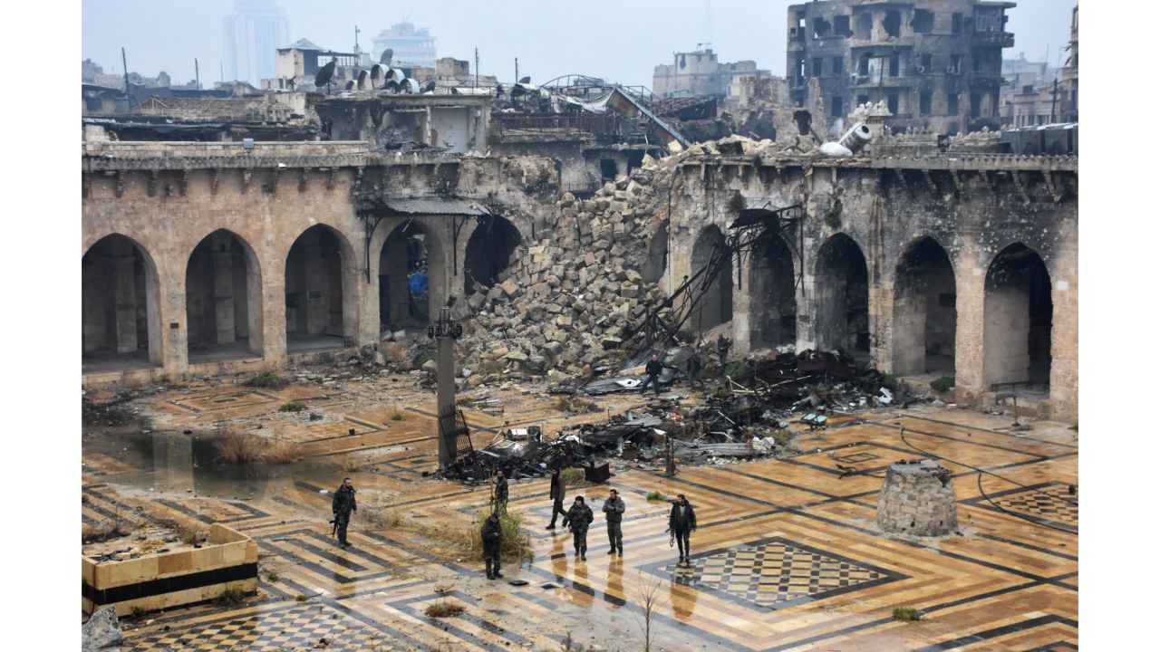 Syrian pro-government forces walking in the ancient Umayyad mosque in the old city of Aleppo after they captured the area.