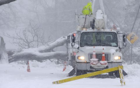 Workers remove a fallen tree from a road in Norwell, Massachusetts, on March 13.