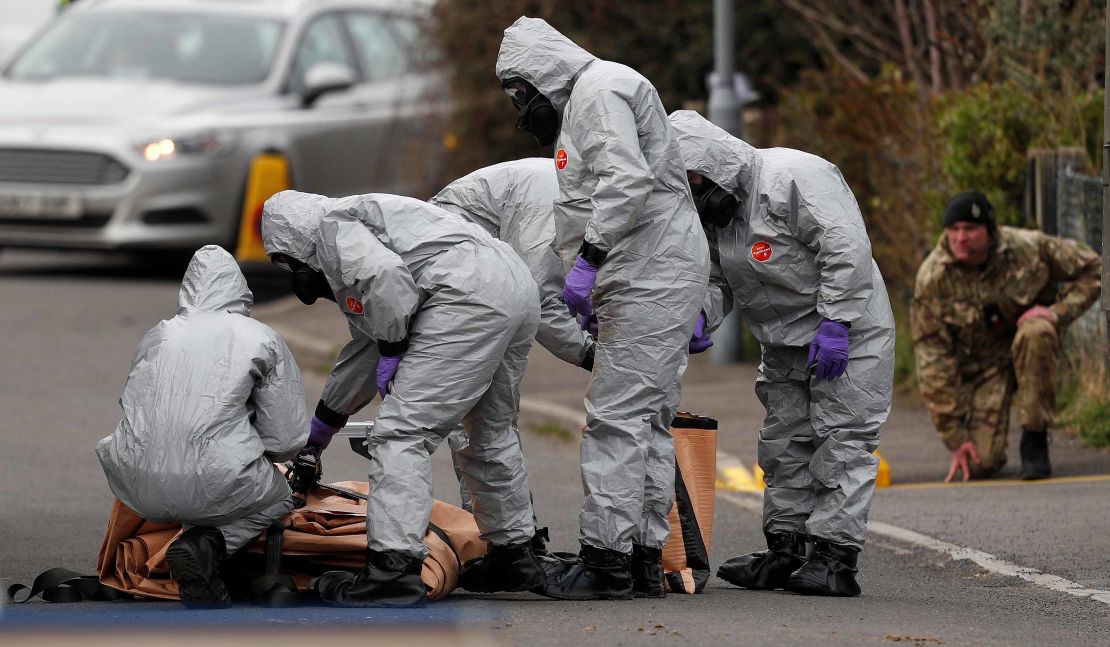 British military personnel wearing protective coveralls work to remove a vehicle connected to the March 4 nerve agent attack in Salisbury.