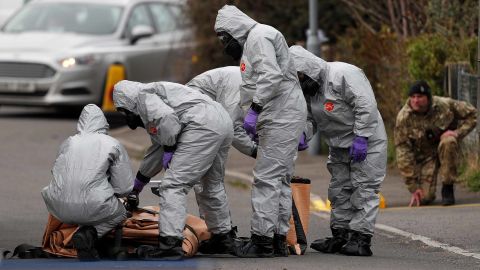 British military personnel wearing protective coveralls work to remove a vehicle connected to the March 4 nerve agent attack in Salisbury.
