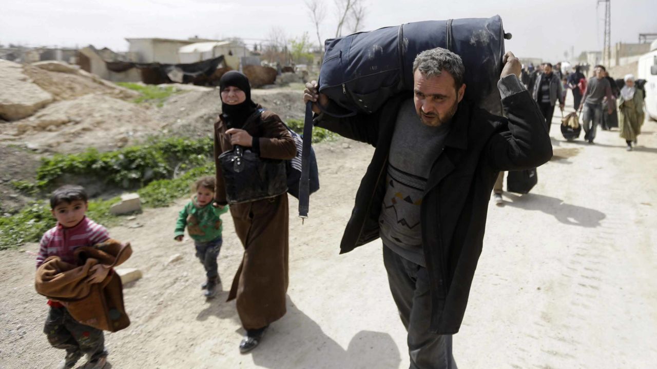 Syrians from rebel-held Eastern Ghouta arrive at the regime-held checkpoint in Adra, on the northeastern outskirts of Damascus, after escaping the enclave through a corridor opened by the government forces on March 15, 2018. 
Thousands of civilians poured out of Syria's Eastern Ghouta bringing the government closer to retaking the rebel enclave near the capital as the brutal war enters its eighth year.  / AFP PHOTO / LOUAI BESHARA        (Photo credit should read LOUAI BESHARA/AFP/Getty Images)