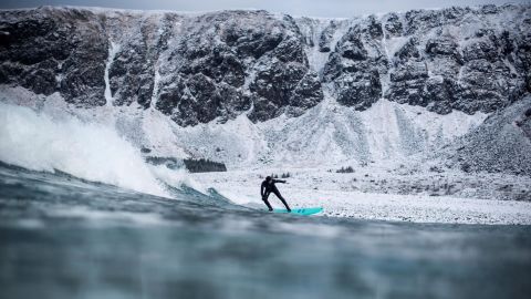 A surfer rides a wave in Unstad, Norway, on Saturday, March 10.