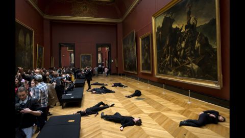 Members of the environmental activist group 350.org lie on the floor during a protest at the Louvre museum in Paris on Monday, March 12. The group was protesting the museum's sponsorship deal with the oil firm Total.