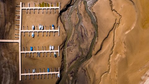 Stranded boats are seen on a dried-up shore of Switzerland's Lake of Gruyere on Wednesday, March 14. The artificial reservoir's water level is being reduced to make room for melting snow that will soon be coming from the surrounding mountains.