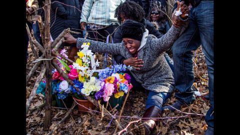 Fatmata Corneh cries at a memorial constructed for her daughter, Mujey Dumbuya, in Kalamazoo, Michigan, on Sunday, March 11. Mujey, 16, was found dead in Kalamazoo in January.