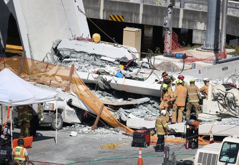 Rescue teams look for victims in cars trapped in the rubble.