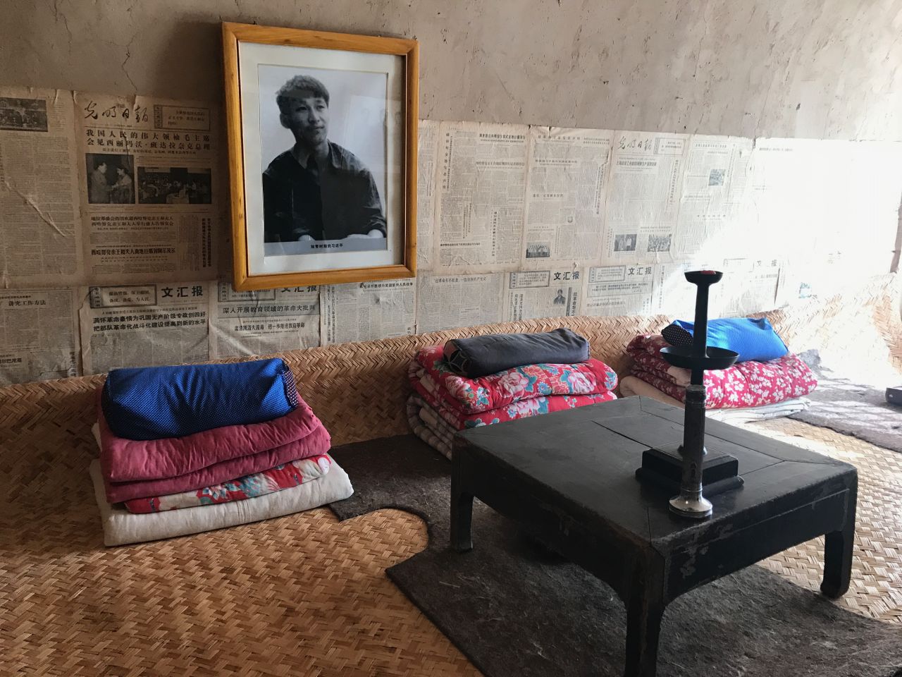 A photo of a youthful Xi as well as old newspapers adorn the wall above his old shared bed in a "cave house."