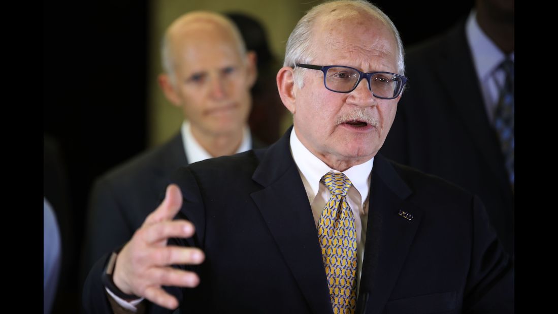 The president of Florida International University, Mark Rosenberg, speaks to reporters with Florida Gov. Rick Scott behind him. Rosenberg said FIU followed required processes during the bridge's construction and all contractors were certified by the state.