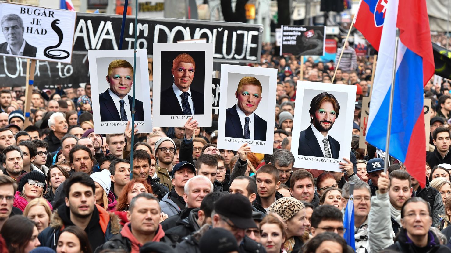 Protesters hold placards showing altered portraits of Slovakia government figures on Friday.