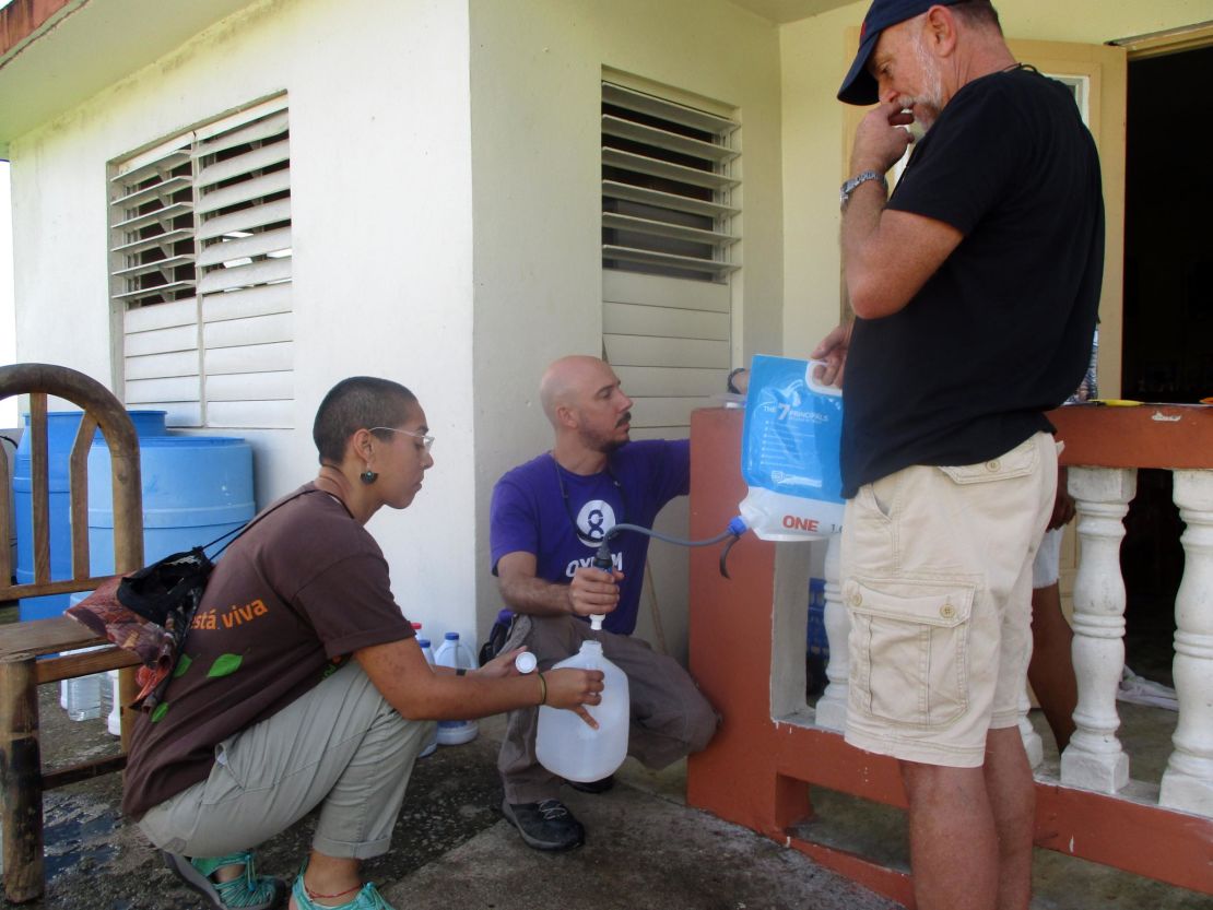 Volunteers Pablo Méndez Lázaro, Lenulisy Rosado and William Preston demonstrate water filtration to Montones residents.