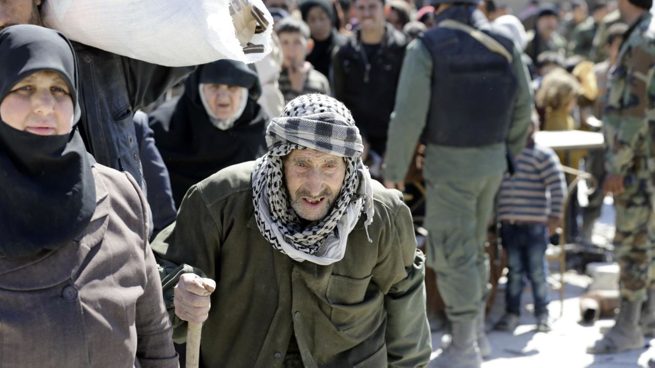 Syrian civilians, evacuated from rebel-held areas in the Eastern Ghouta, gather at a school in the regime-controlled Hosh Nasri, on the northeastern outskirts of the capital Damascus on March 16, 2018, ahead of being relocated to other areas.
On the edge of Ghouta, a sprawling semi-rural area within mortar range of central Damascus, hundreds of civilians were still streaming out of destroyed towns, carrying scant belongings in bags and bundles. / AFP PHOTO / LOUAI BESHARA        (Photo credit should read LOUAI BESHARA/AFP/Getty Images)