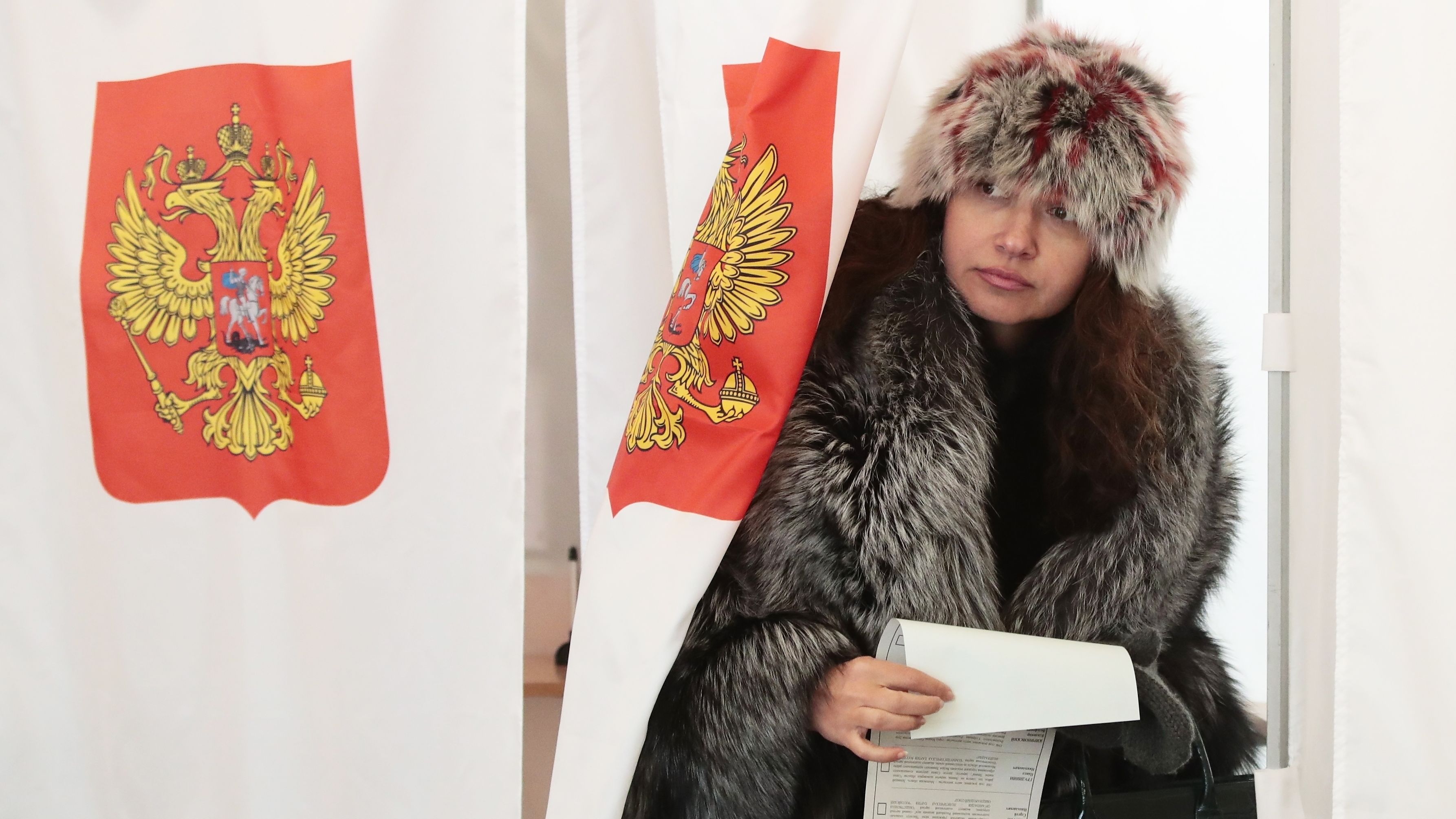 A woman exits a polling booth as she prepares to cast her ballot in the presidential election in Moscow.