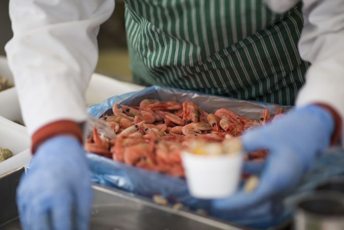 Fishmonger Dave Crosbie's wife serves customers at their stall in the market.