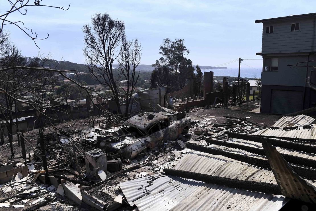 Debris from destroyed homes and a burnt-out car covers the ground in Tathra, Australia.