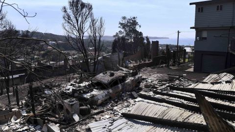 Debris from destroyed homes and a burnt-out car covers the ground in Tathra, Australia.