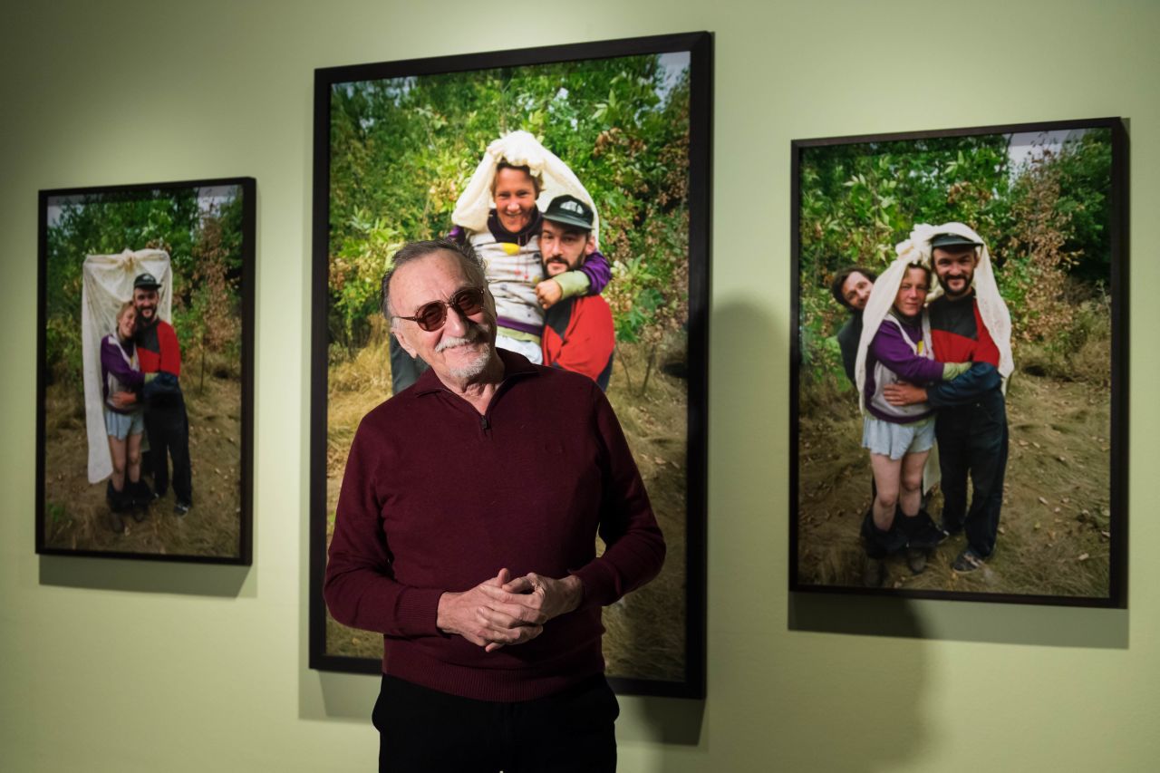Boris Mikhailov poses in front of photos from his "The Wedding" series, part of "Another Kind of Life: Photography on the Margins" at the Barbican Art Gallery.