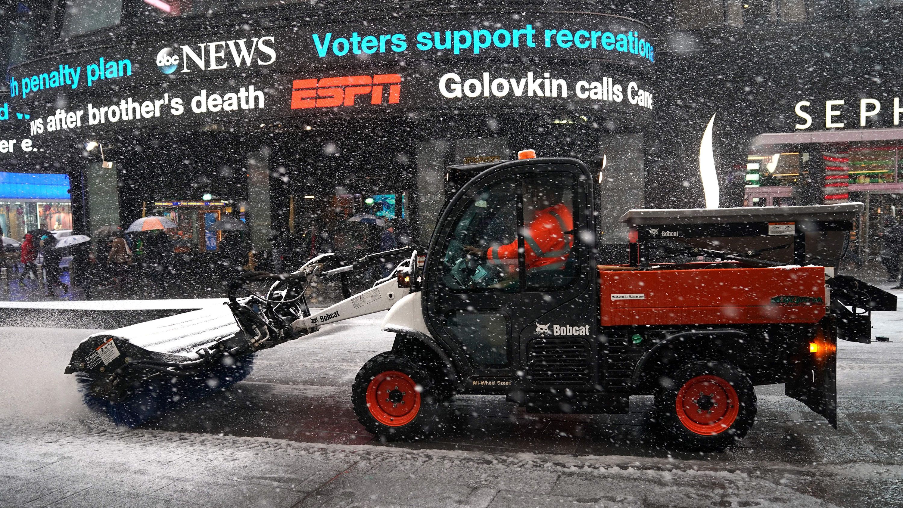 Workers in New York's Times Square battle the fourth nor'easter in a month Wednesday.