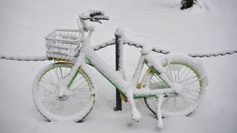 Snow covers a LimeBike rental bicycle Wednesday in Washington.