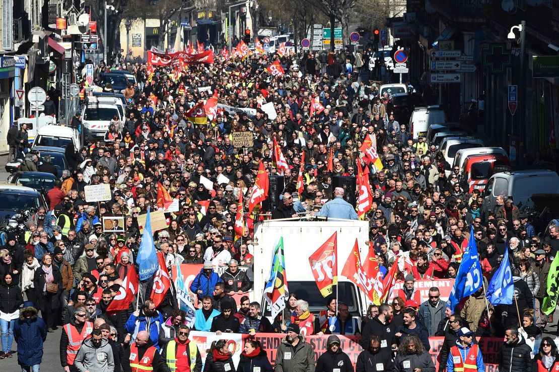 People hold CGT union flags as they march in protest of the French government's string of reforms on Thursday in the southern French city of Marseille.
