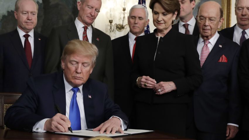 President Donald Trump signs a presidential memorandum imposing tariffs and investment restrictions on China in the Diplomatic Reception Room of the White House, Thursday, March 22, 2018, in Washington.