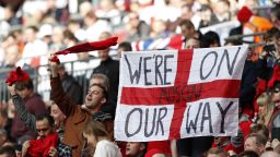 England supporters hold up a "we're on our way" slogan on an England flag in the crowd ahead of the World Cup 2018 qualification football match between England and Lithuania at Wembley Stadium in London on March 26, 2017. 