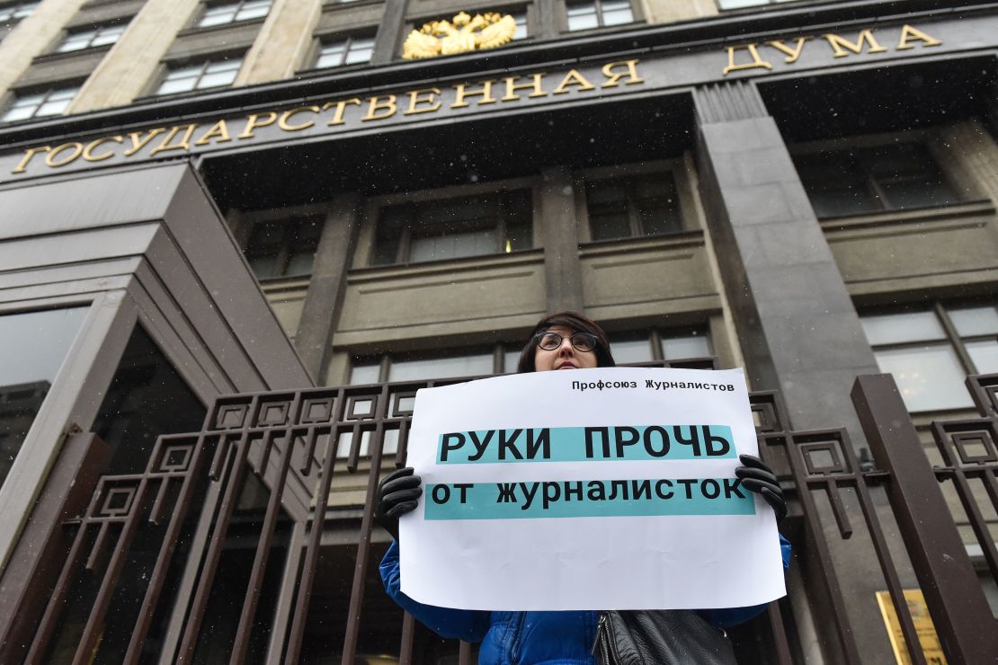 A woman protesting outside the State Duma building in Moscow on Wednesday holds a placard reading "hands off from female journalists."