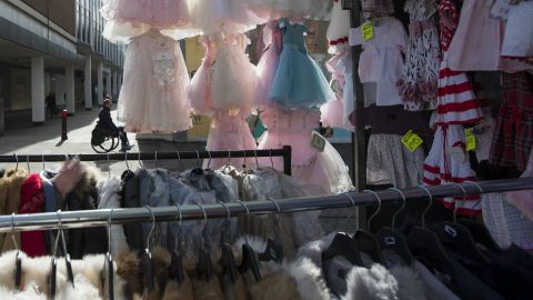 Children's ruffled dresses hang from a stall in Romford Market.