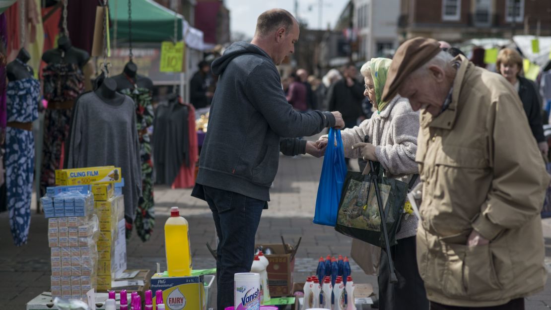 Gibbons serves customers at his stall in Romford Market.